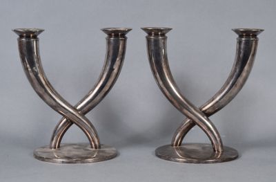 two silver candlesticks that are sitting on a table