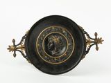 an image of a black and gold plate with a woman ' s head