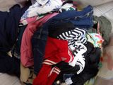 a pile of clothes that is on a bed