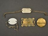 a close up of a metal bracelet with a chain and two tags