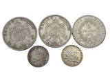 a group of five silver coins sitting on top of each other