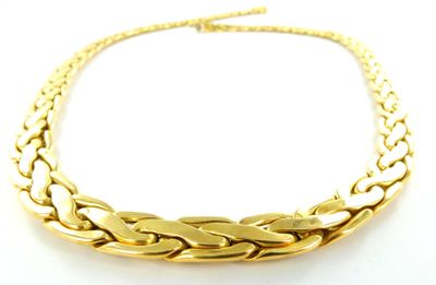 gros plan d'un collier en or sur une surface blanche
