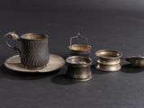 a cup, saucer, and spoon on a table