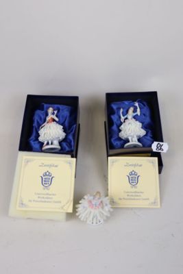 pair of porcelain figurines of ballerinas in boxes on a table