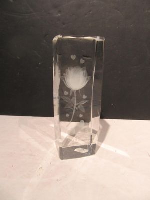 un vase en verre avec une fleur à l'intérieur sur une table