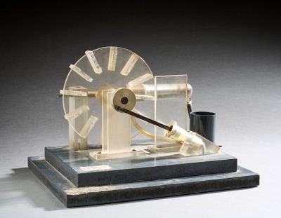 une petite maquette de roue à eau posée sur un socle