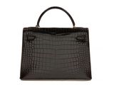 a black crocodile skin handbag on a white background