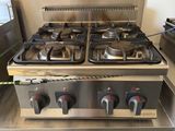 une plaque de cuisson argentée à trois feux sur laquelle sont posées deux casseroles