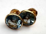 pair of gold tone earrings with a blue topazt stone
