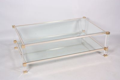 une table basse en verre et en laiton sur fond blanc