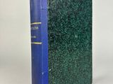un livre bleu et vert posé sur une table blanche