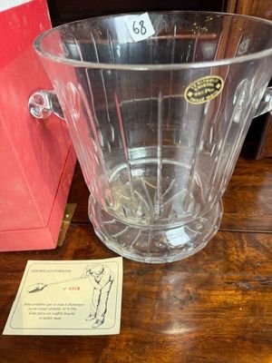 un pichet en verre transparent posé sur une table à côté d'une boîte rouge