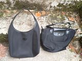 black leather handbag on the ground next to a rock