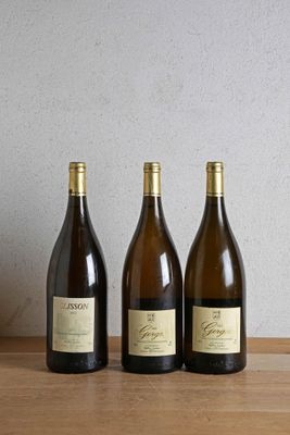 three bottles of wine are lined up on a wooden table