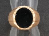 une bague sertie d'une pierre noire, posée sur une table