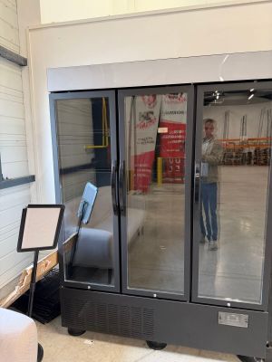 un homme qui se tient devant une porte coulissante en verre