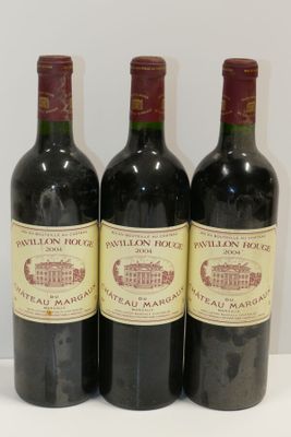 trois bouteilles de vin sont alignées sur une surface blanche