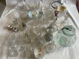 une nappe blanche sur laquelle sont disposés de nombreux objets en verre
