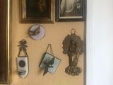 une photo d'un mur sur lequel sont accrochés des tableaux et une horloge