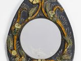 a mirror with a design on it hanging on a wall