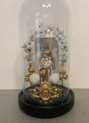 a glass dome with a statue inside of it on a table