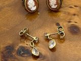 deux paires de boucles d'oreilles et une bague posées sur une table en bois