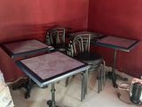 plusieurs tables et chaises dans une pièce dont l'un des murs est rouge