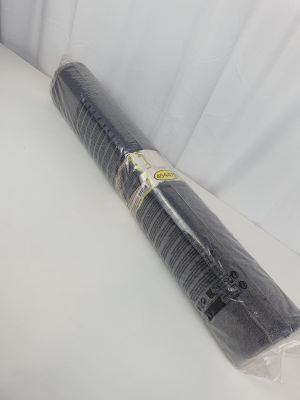un rouleau de plastique noir posé sur une surface blanche