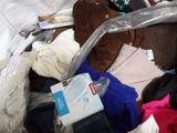 a pile of clothes that is sitting on a bed