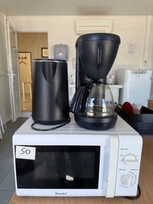 a coffee maker and a coffee pot on top of a microwave