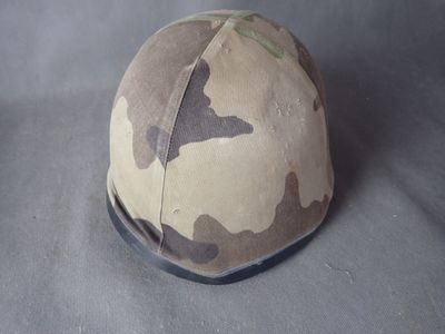 a helmet with a camouflage pattern on it sitting on a table