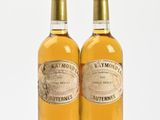deux bouteilles de vin blanc posées l'une à côté de l'autre sur une surface blanche