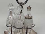 a silver tray with three glass bottles and a silver handle