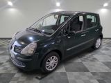 une photo d'une petite voiture verte garée dans un garage