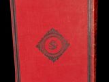 an old book with a red cover and a black border