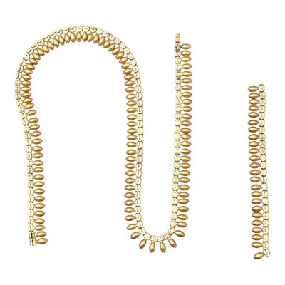 un gros plan d'un collier et d'un bracelet sur fond blanc