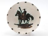 a plate with a picture of a man riding a horse