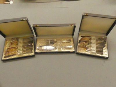 trois boîtes ouvertes contenant des pièces d'or, posées sur une table