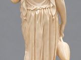 statue of a woman holding a vase on a marble base