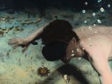 a man that is swimming in the water with bubbles