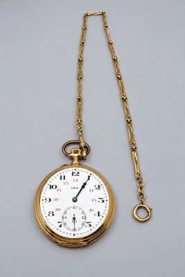 une montre de poche en or ancien, avec une chaîne suspendue sur le côté