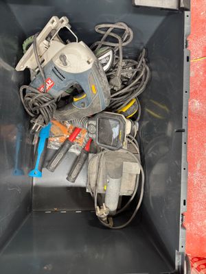 a metal container with tools in it on the floor