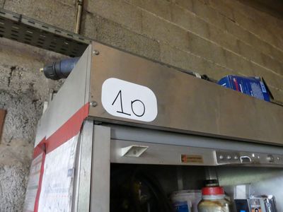 an image of a stainless steel refrigerator with a sign on it