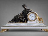 une statue représentant une femme assise sur un banc, avec une horloge devant elle