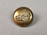 une image représentant un bouton en or orné d'une tête d'aigle