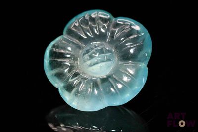 a glass object that looks like a flower on a black surface
