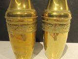 two gold vases sitting on a white table