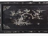 a black tray with flowers and birds painted on it