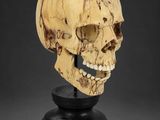a carved skull head on a black stand