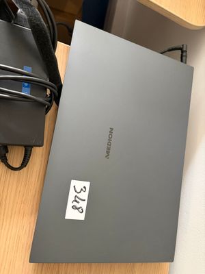 un ordinateur portable posé sur un bureau à côté d'un sac